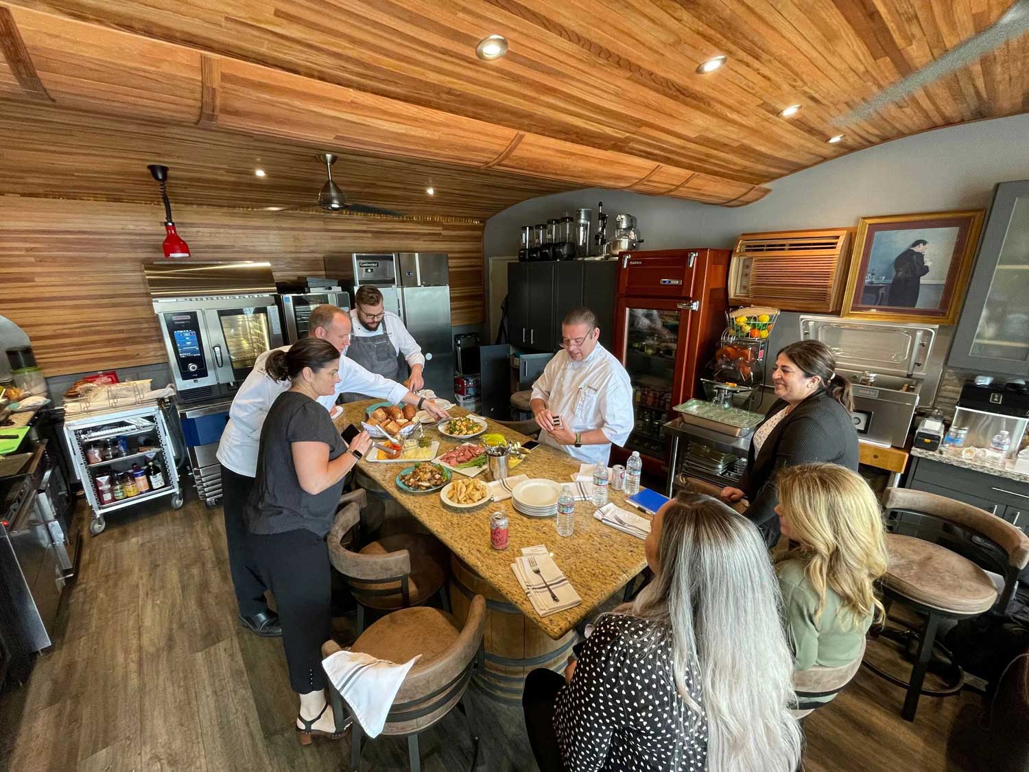 Guests participating in a commercial equipment demo at an Inform Foodservice Solutions test kitchen.